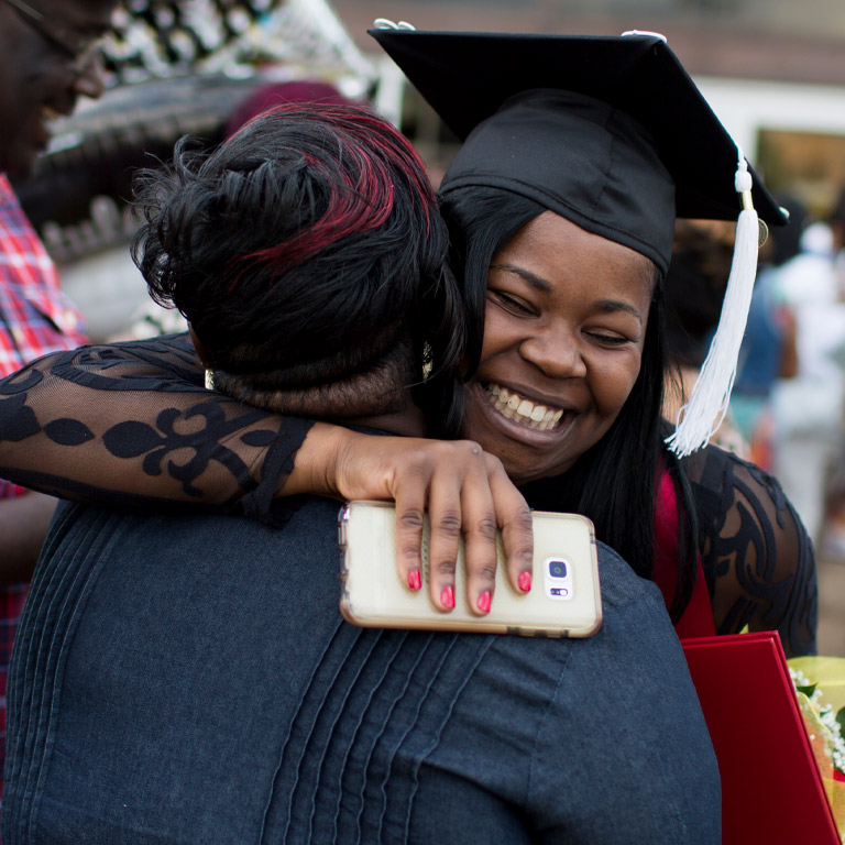 A young IU Northwest graduate hugs one of her relatives at Commencement